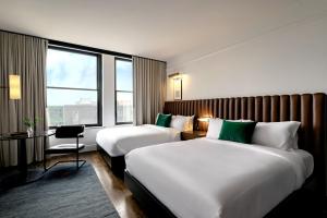 a hotel room with two beds and a desk and a window at Surety Hotel in Des Moines