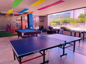 una sala de ping pong con 2 mesas de ping pong en Apartamento Encantador Samaria Club de playa, 3 alcobas 6 personas Playa Privada, en Santa Marta