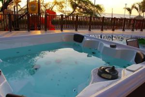 a jacuzzi tub in a pool with the ocean in the background at Apartamento Encantador Samaria Club de playa, 3 alcobas 6 personas Playa Privada in Santa Marta