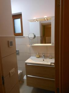 La salle de bains est pourvue d'un lavabo, d'un miroir et de toilettes. dans l'établissement Ţestoasa Montana Sinaia, à Sinaia