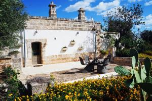 un edificio de piedra con un banco en un jardín en Villa Torretta San Martino en Pezze di Greco