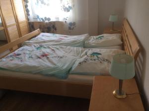 ein Bett mit weißer Bettwäsche und Vögeln darauf in der Unterkunft Apartment am Lift in Hahnenklee-Bockswiese