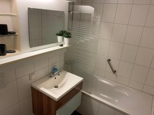 ein weißes Bad mit einem Waschbecken und einer Dusche in der Unterkunft Apartment am Lift in Hahnenklee-Bockswiese