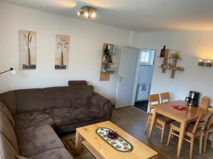 ein Wohnzimmer mit einem Sofa und einem Tisch in der Unterkunft Apartment am Lift in Hahnenklee-Bockswiese