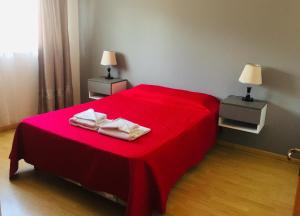 a red bed with two towels on top of it at Newen in El Calafate