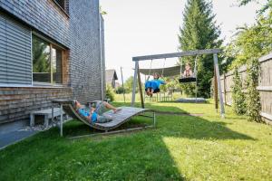 two people laying on a swing in a yard at Terrassenwohnung 9 in Klaus