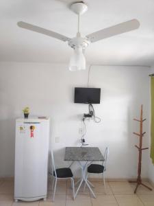 Camera con tavolo e ventilatore a soffitto. di Pousada Sol e Lua a São Thomé das Letras