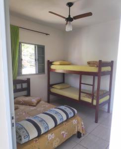 una camera con 2 letti, un letto a castello e un ventilatore a soffitto di Pousada Sol e Lua a São Thomé das Letras