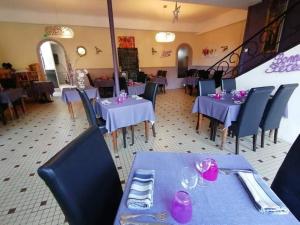 une salle à manger avec des tables et des chaises bleues ainsi que des tables et des chaises violettes dans l'établissement Hotel Bayle, à Belcaire