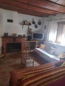 sala de estar con sofá y chimenea en La Cañada, en Yeste