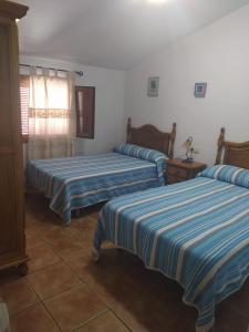 um quarto com duas camas com riscas azuis e brancas em La Cañada em Yeste