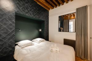 une chambre avec un grand lit avec des oreillers blancs dans l'établissement L'Appart' - Ideal for a stay in the city center near the Lake, à Annecy