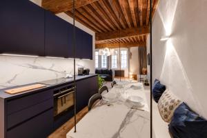 une cuisine avec des armoires bleues et des comptoirs blancs dans l'établissement L'Appart' - Ideal for a stay in the city center near the Lake, à Annecy