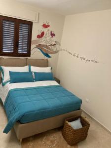 a bedroom with a bed with a blue comforter and a painting at LeVolte luxury suite&spa in Sternatia