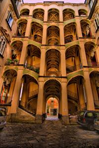 ein großes Gebäude mit einem Torbogen im Innenhof in der Unterkunft Casa Marmolo - Cuore di Napoli in Neapel