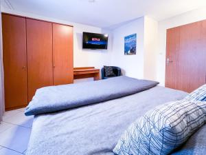 a bedroom with a bed and a desk with a television at swissme - 100qm - Balkon - 2 Bäder - Parkplatz - Fußbodenheizung in St. Moritz