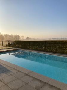 a swimming pool in a yard with a fence at Maison mystique in Staden