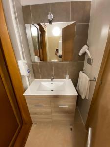 y baño con lavabo y espejo. en Hotel Rural Finca Aldeola, en Malpica de Bergantiños