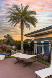 a hammock and a palm tree in front of a house at Ocean Coast Hotel at the Beach Amelia Island in Fernandina Beach