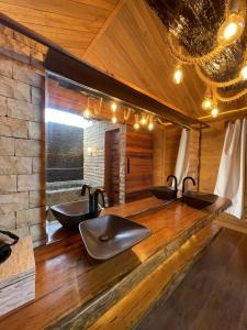 a bathroom with three sinks and a brick wall at Collina Beach in Amontada