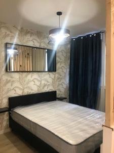 a bedroom with a bed and a mirror at LOFT T2 by locations_lepuyenvelay in Le Puy en Velay