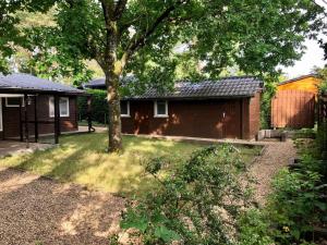 een huis met een boom in de tuin bij Le Coton in Resteigne