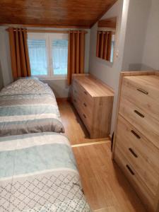 een slaapkamer met 2 bedden en een dressoir bij Le Coton in Resteigne