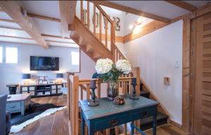 モルジヌにあるBeautiful 3 Bedroom Chalet in Morzineのテーブルの上に花瓶が置かれた階段のあるリビングルーム +8枚の写真