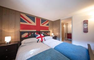 モルジヌにあるBeautiful 3 Bedroom Chalet in Morzineのベッドルーム1室(壁に旗を掲げたベッド1台付)