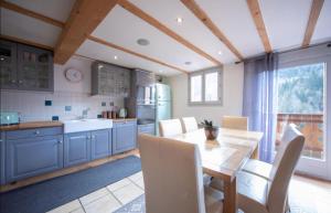モルジヌにあるBeautiful 3 Bedroom Chalet in Morzineの青いキャビネットとテーブルと椅子のあるキッチン