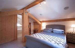 Beautiful 3 Bedroom Chalet in Morzine في مورزين: غرفة نوم بسرير في غرفة بجدران خشبية