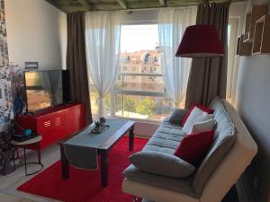 a living room with a couch and a tv and a table at Lovely penthouse with an indoor fireplace in Sofia