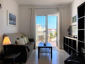 uma sala de estar com um sofá, uma mesa e uma janela em Chimenea Pinar 1D Apartments Casasol em Nerja