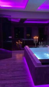 um quarto com uma banheira com luzes roxas em Loft mit Whirlpool Sauna Kino nähe Wolfsburg em Helmstedt