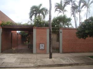 a red brick fence with a gate and palm trees at Sur Backpackers in Santa Cruz de la Sierra