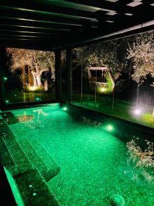 una piscina por la noche con luces verdes en I Capricci Di Merion - Resort & Spa, en Tuoro sul Trasimeno