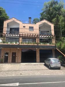 a house with a car parked in front of it at Pousada Blumenau in Blumenau