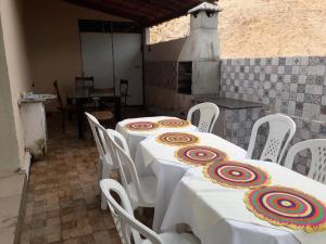 uma sala de jantar com uma mesa e cadeiras brancas em Pousada Chalés do Castelo em Icapuí