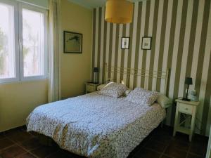 a bedroom with a bed with a striped wall at At the center & very close to the Paseo beach, with double garage, renovated and fully equipped apartment in Almuñécar