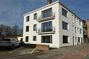 un edificio blanco con un coche aparcado en un aparcamiento en ABC Boutique Apartments, en Brujas