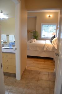 a bedroom with a bed and a sink and a mirror at Salish B&B and Spa in West Kelowna