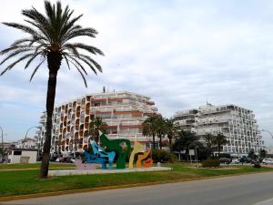 a palm tree and a building with a palm tree at Apartamento Bahia I in Empuriabrava