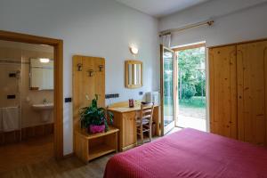 sypialnia z łóżkiem i biurkiem oraz łazienka w obiekcie HOTEL La Locanda w mieście Pinzolo +37 zdjęć