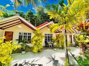 a house with palm trees in front of it at Manta Stay Thoddoo, Maldives in Thoddoo