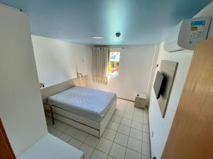 a small room with a bed and a tv at Apartamento Marulhos Porto de Galinhas in Porto De Galinhas