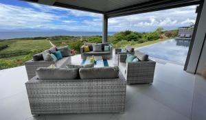 un patio con sofás y vistas al océano. en Villa Belle Galante en Les Basses