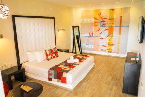 um quarto com uma grande cama branca num quarto em In Fashion Hotel & Spa em Playa del Carmen