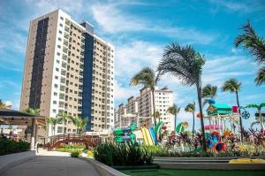 un parco giochi di fronte a due alti edifici con palme di Salinas Park Resorte Salinopolis a Salinópolis