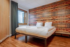 a bedroom with a large bed with a colorful wall at Generator Stockholm in Stockholm
