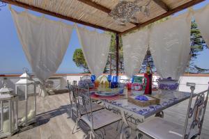 a table with chairs on a patio with a view of the ocean at Lacco Terrace Solarium in Ischia